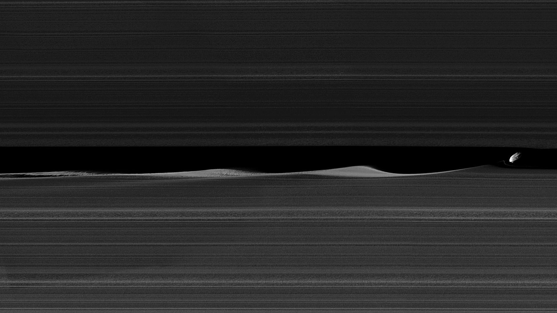 Cassini photograph of Daphnis in the Keeler Gap, raising waves in the ring ice